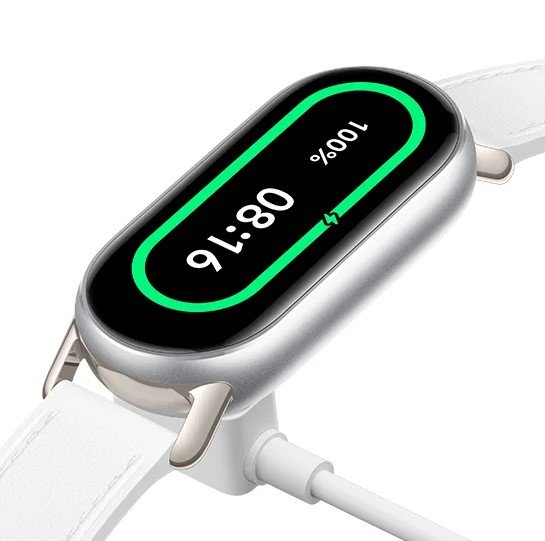 Xiaomi Smart Band 9 conectada ao cabo do carregador magnético traseiro, exibindo 100% de bateria na tela brilhante.